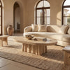 Natural stone coffee table in a warm Mediterranean living room with linen upholstery and neutral finishes.