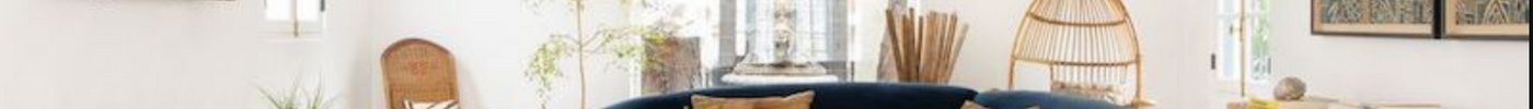 A Mediterranean-inspired living room featuring warm neutral colours, natural stone, textured wall art, wooden furniture and handcrafted ceramics, creating a timeless, elegant and inviting interior inspired by the coastal homes of Southern Europe.