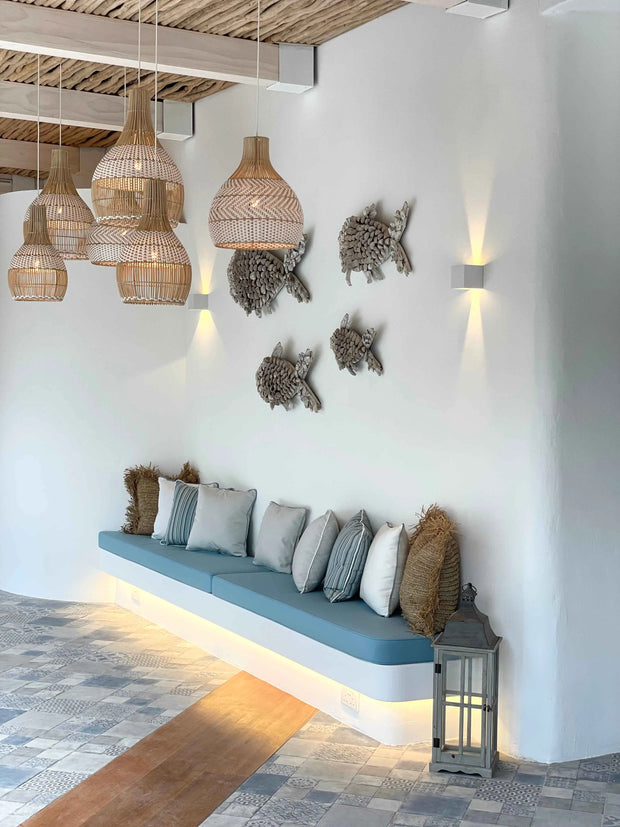 Charming Greek restaurant interior featuring eco-friendly materials and rattan lights, designed in light blue tones by Theodora Martinou from Irregular Lines
